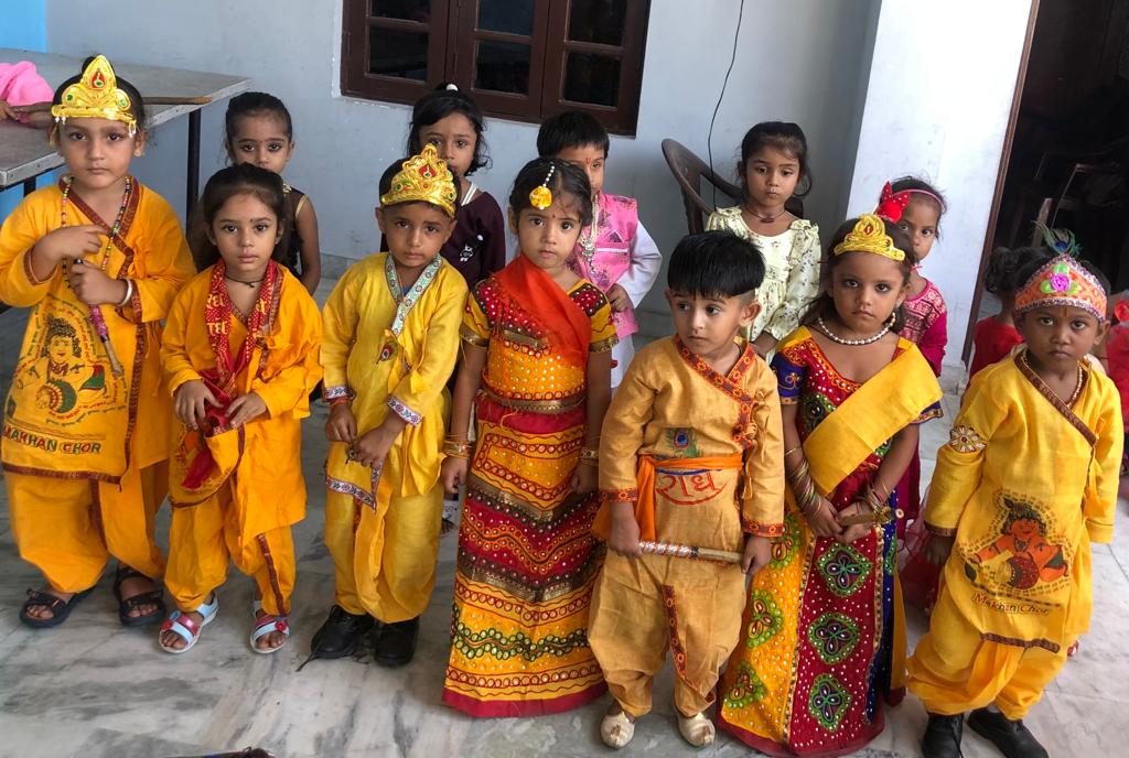 Nursery children in yellow and red costumes at a school celebration